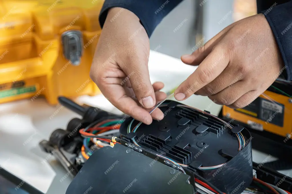 Teknisi sedang memperbaiki kabel fiber optik