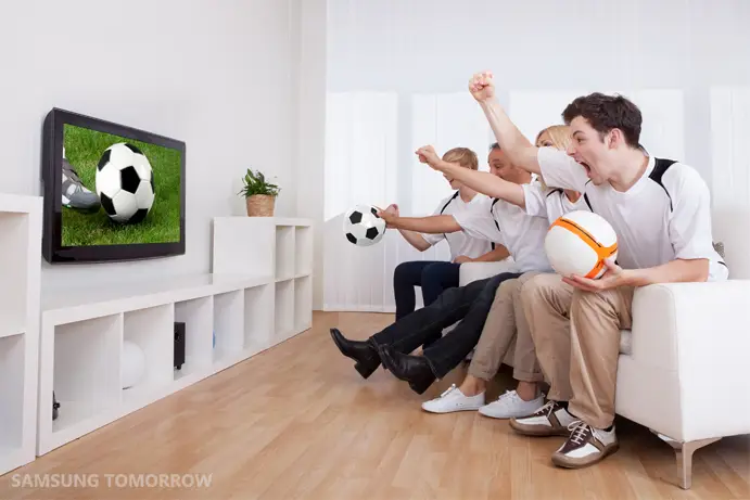 Orang-orang menonton pertandingan sepak bola di TV